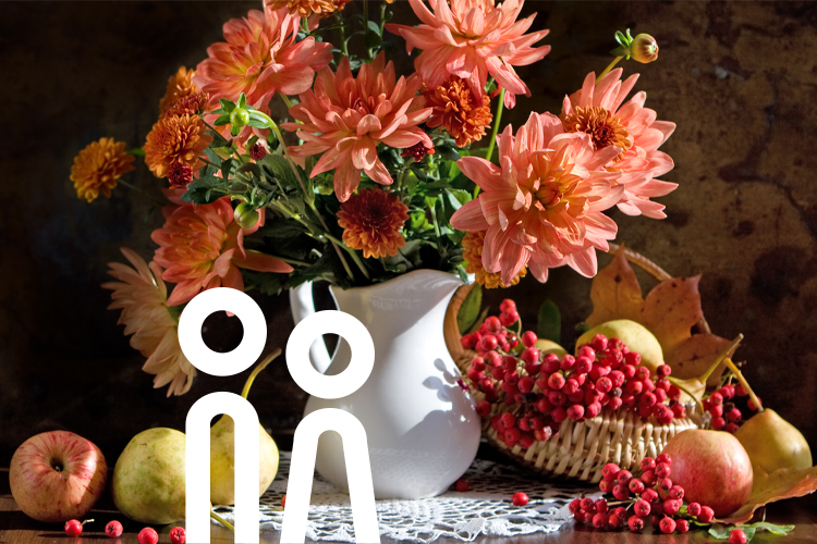 Blomstervas med frukt och bär på ett soffbord.