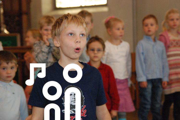 Bild på sjungande barn i kyrkans korridor.
